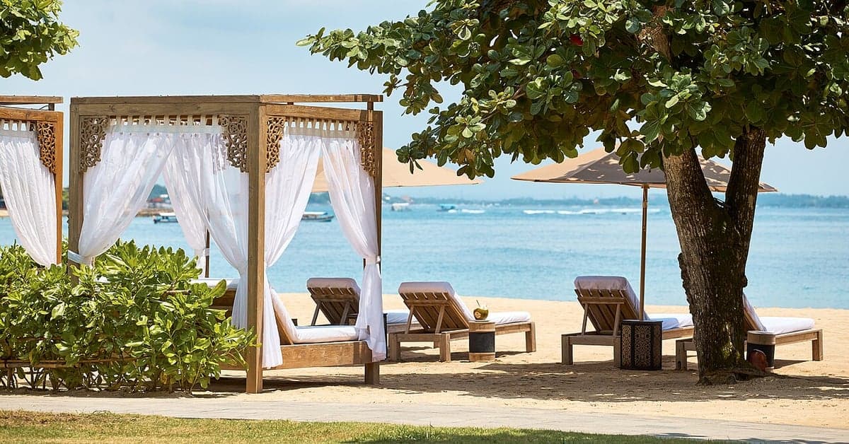 A curtained beach cabana with sun loungers