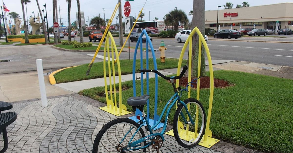 Surfboard-shaped bike racks beside a beach-town street