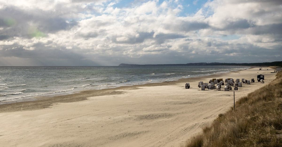 A sandy Baltic Sea beach lined with traditional German roofed beach chairs