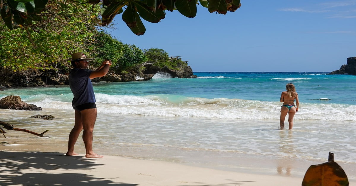 Surfers riding waves at Boston Bay Beach near Port Antonio, Jamaica