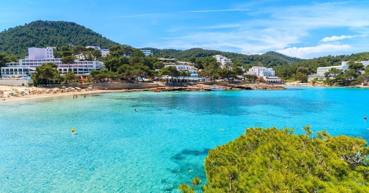 The serene turquoise waters and rocky coastline of Portinatx Beach in northern Ibiza, Spain