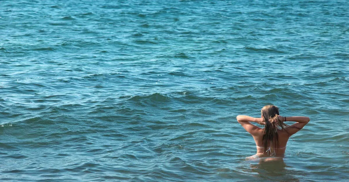 A scenic clothing-optional beach surrounded by natural landscape