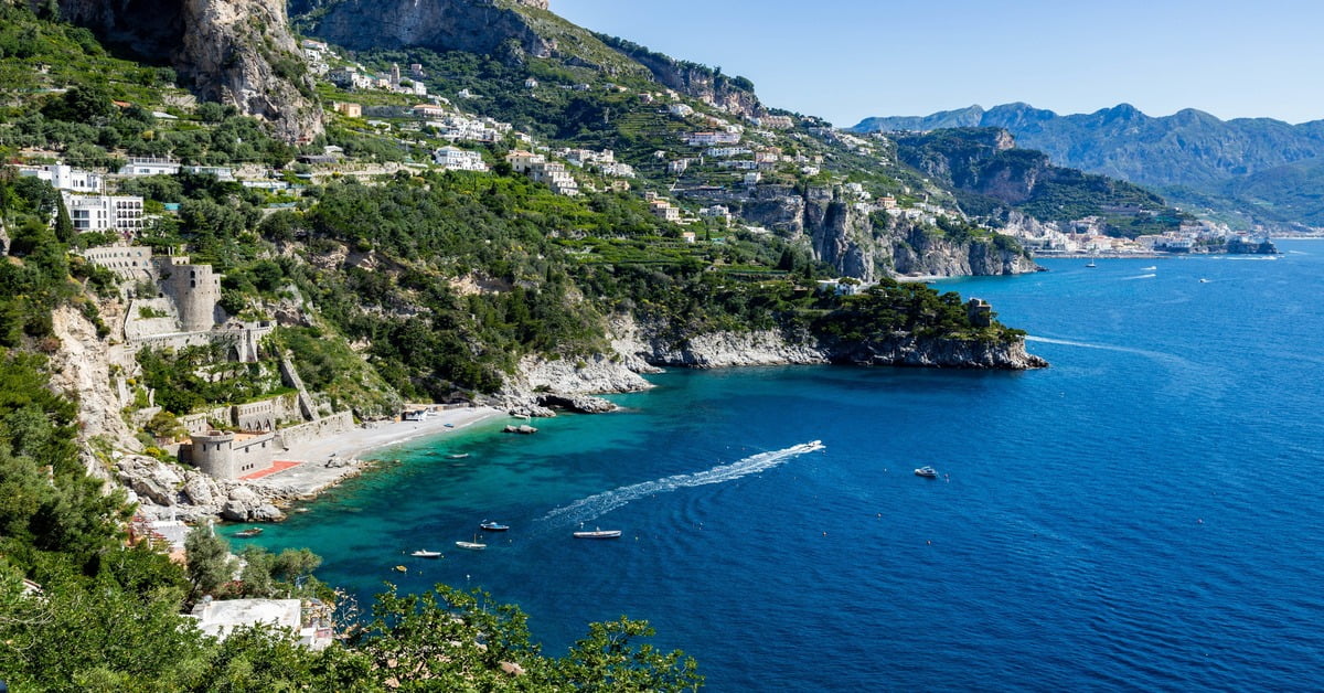 The quiet beach at Conca dei Marini on the Amalfi Coast, sheltered by high cliffs with calm turquoise water