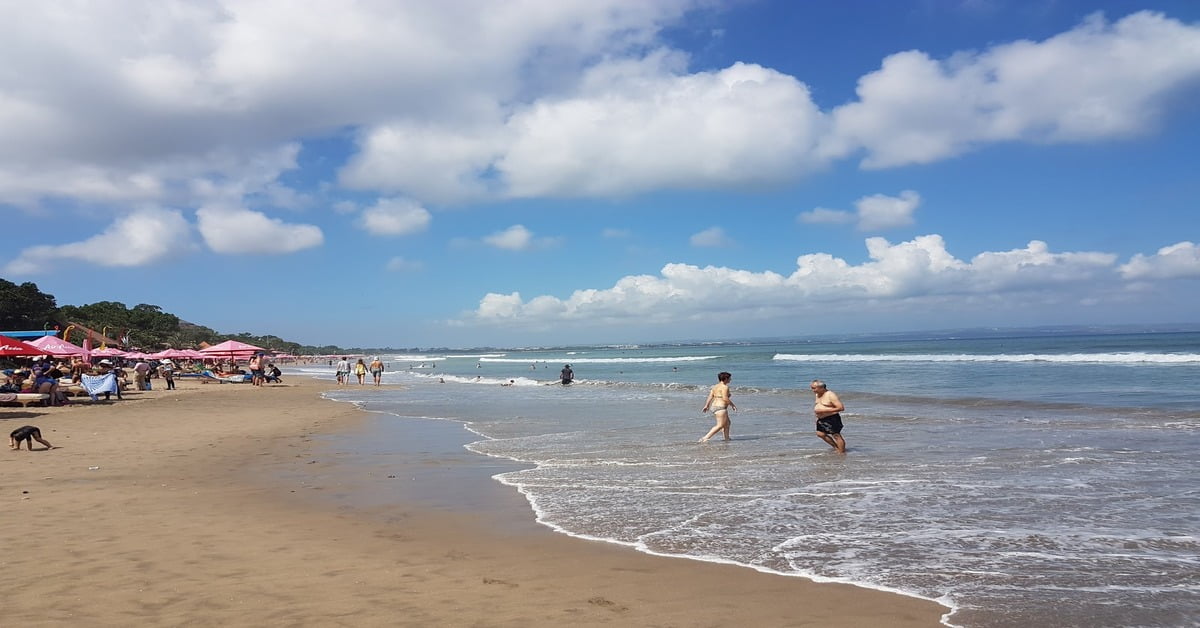 Golden sand and rolling waves at Seminyak Beach in Bali, Indonesia