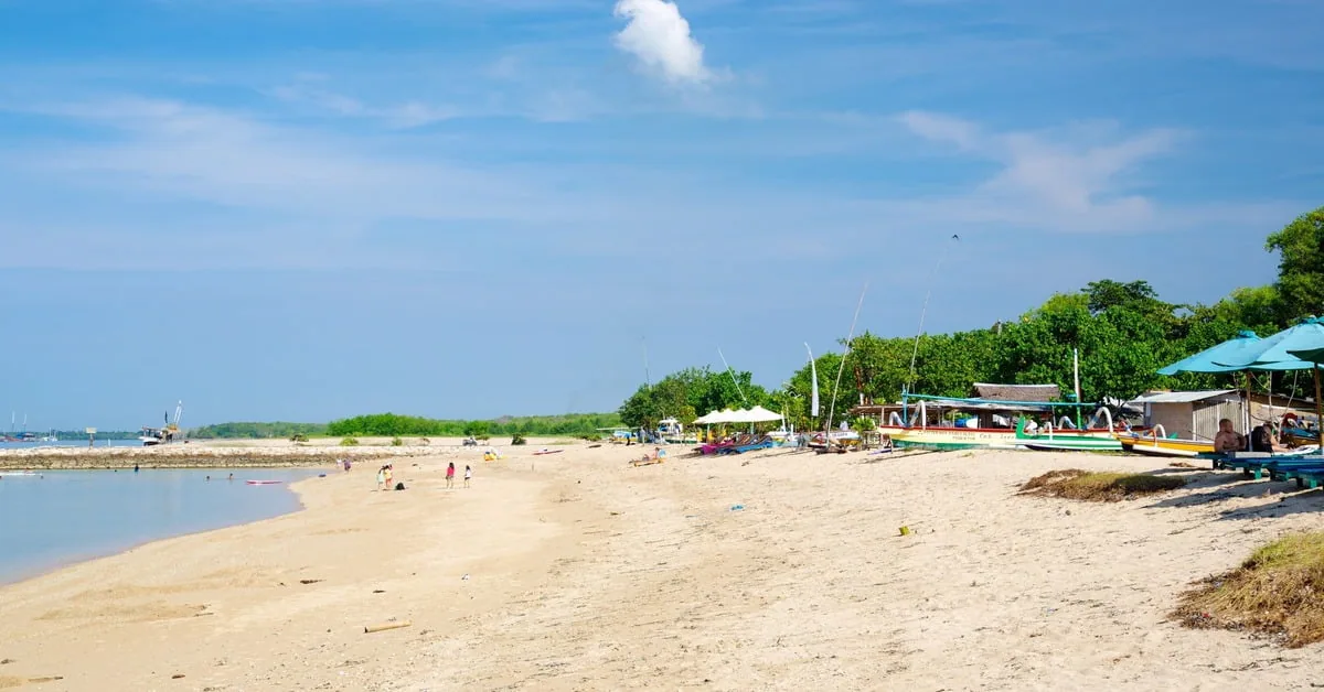 Peaceful Sanur Beach in Bali with traditional outrigger boats and calm morning water