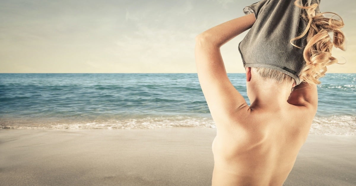 Tropical Caribbean shoreline with turquoise waters and white sand, perfect for naturist travelers